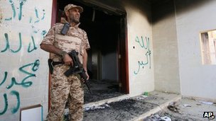  A Libyan soldier guards one of the buildings of the burnt out US consulate in Benghazi, Libya 