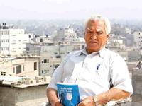  Elderly man sits on rooftop while holding book 